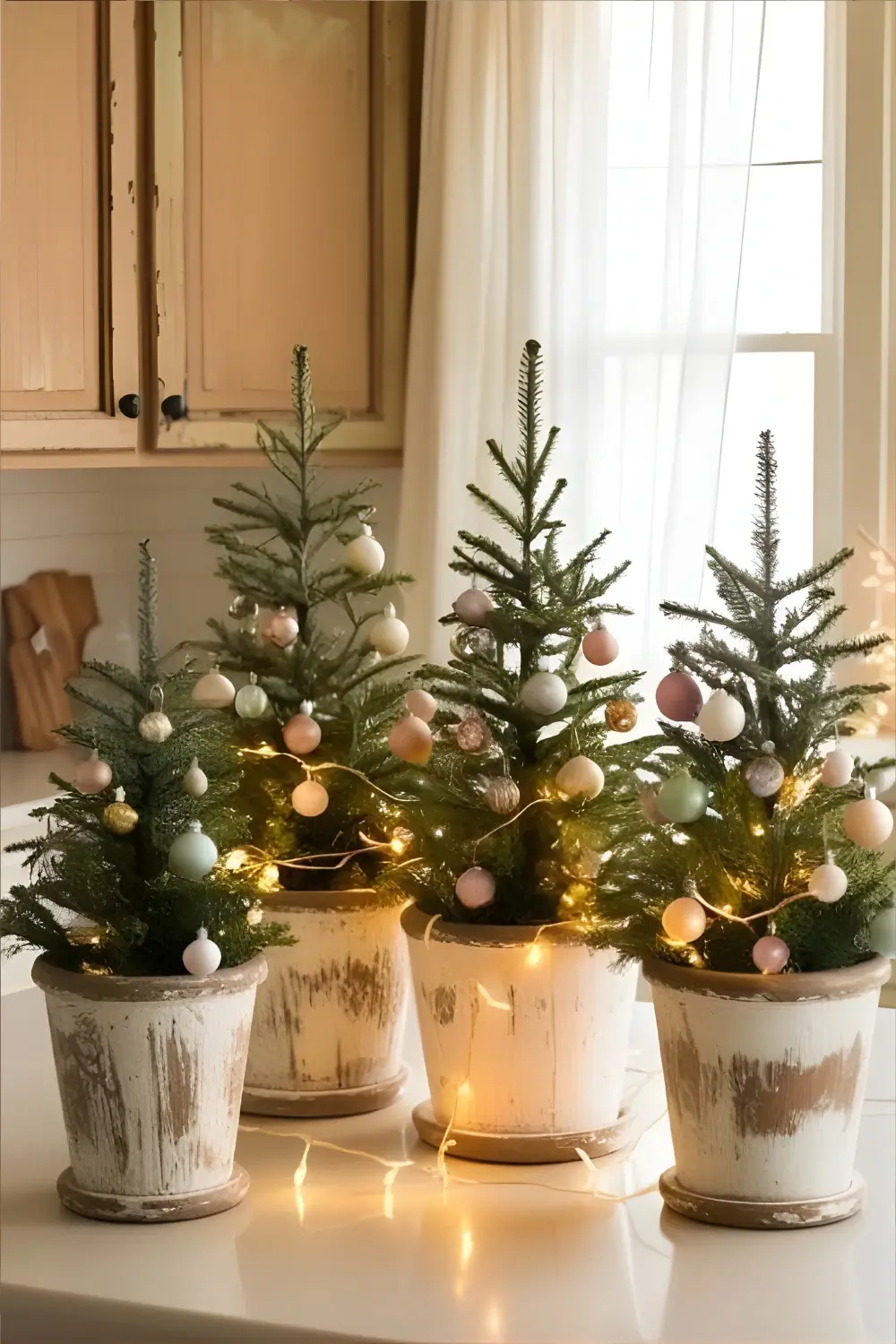 Christmas Cottage Kitchen Décor Ideas: 21 Best Ways to Create a Cozy and Festive Space 17 A kitchen counter with mini Christmas trees in rustic wooden planters, decorated with tiny ornaments and lights.