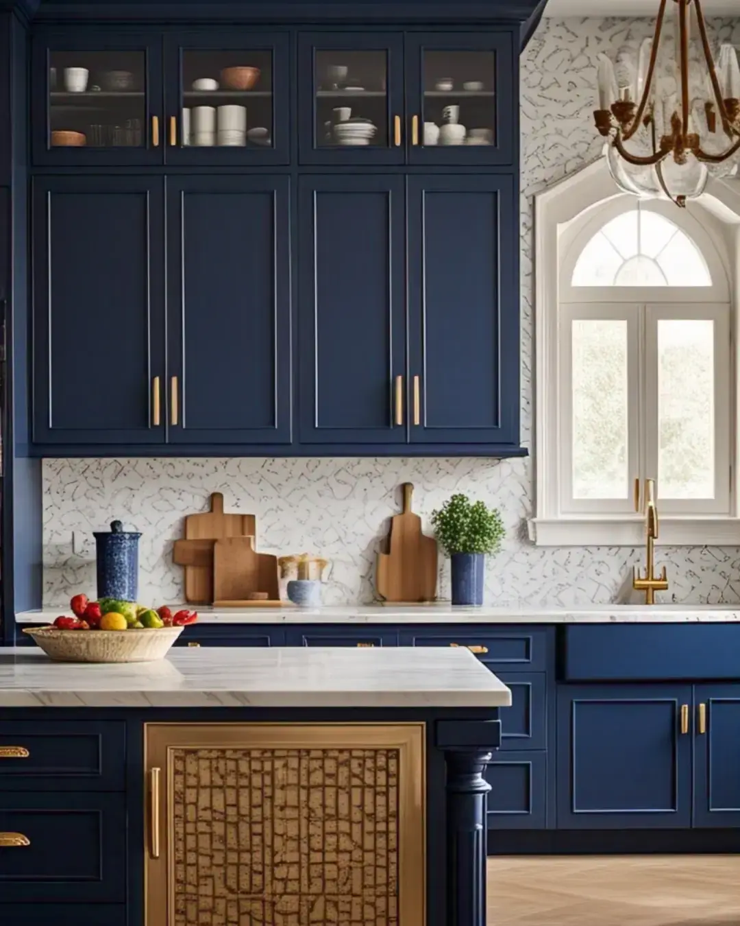 Kitchen Cabinet Colors for White Tile Floors: 11 Best Ideas and Expert Tips 4 a cozy, traditional kitchen with soft gray cabinets, black hardware, a white subway tile backsplash, and white tile floors. There is a wooden table in the corner with a potted plant. A vintage stove and a farmhouse sink are also present. The walls have a beige paint and a few decorative items, such as a wooden rack and a vase. The room has a warm lighting.