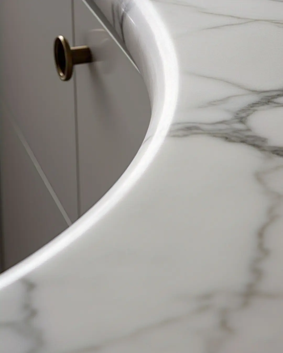 Bullnose edge countertop / Close-up of a white marble countertop with a full bullnose edge, showing the smooth curve reflecting light.