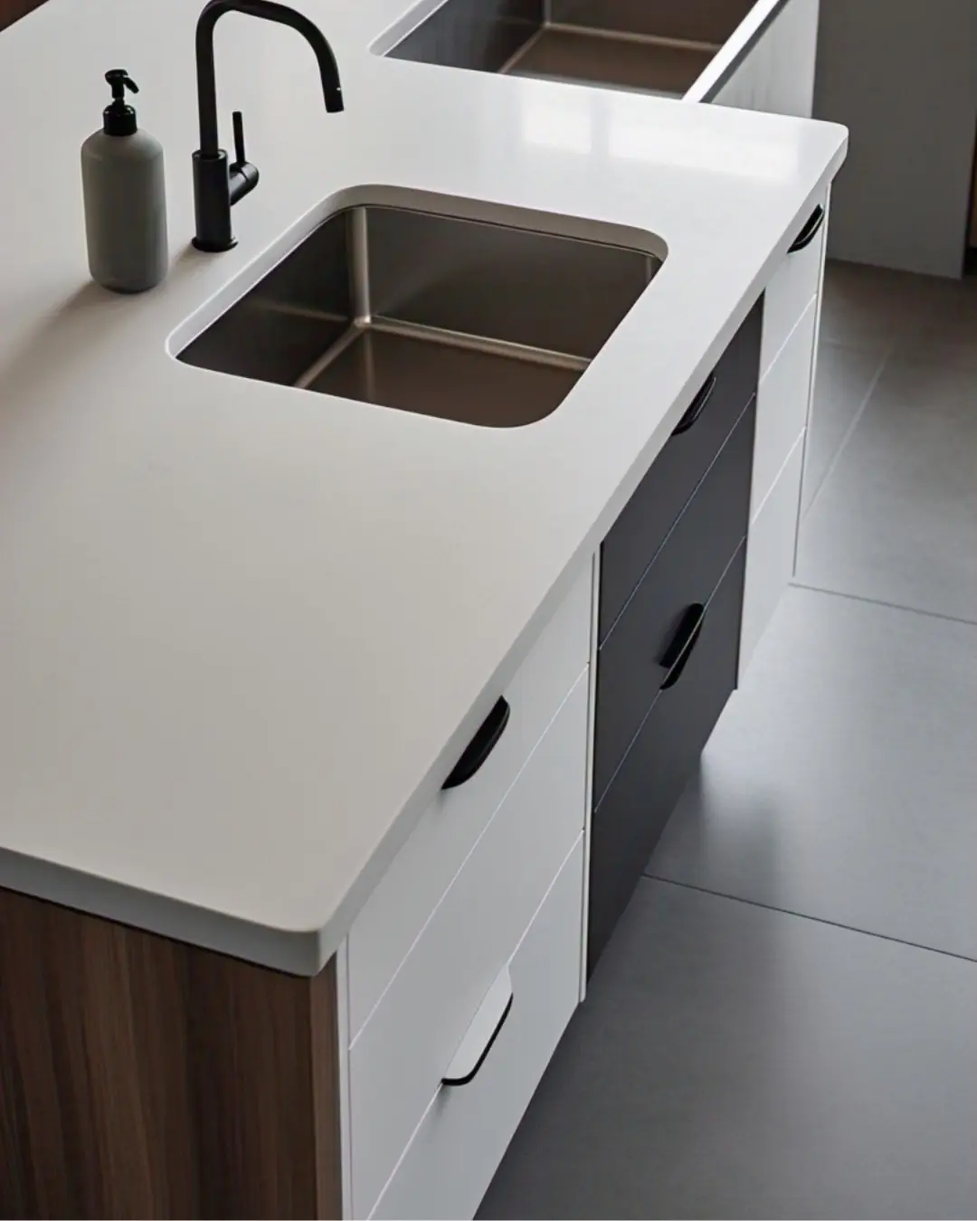 Matte white Corian countertop with a half-bullnose edge and built-in sink, styled with minimalist soap dispensers.